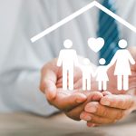 hands holding a family of paper cut out people