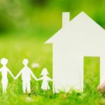 Paper cut out illustration of a family holding hands next to their first home